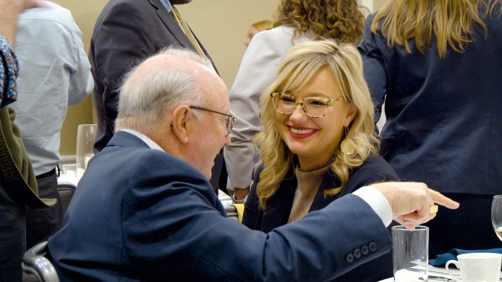 Two attendees sharing a laugh at a banquet table during the summit.