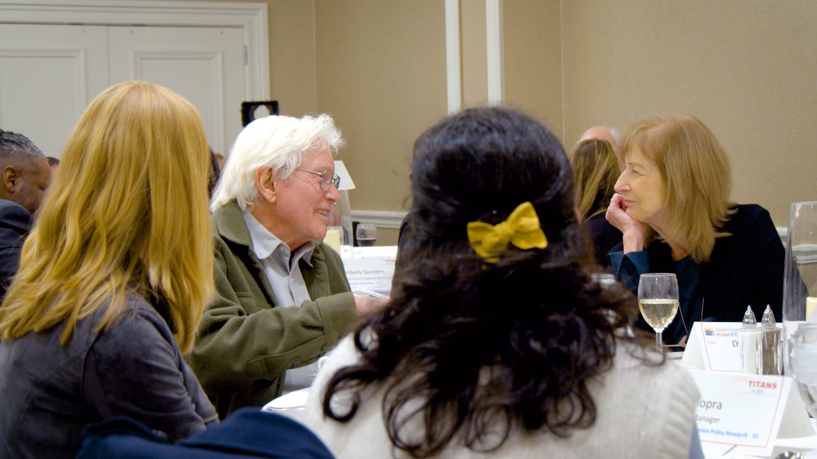 Dr. Peter Gray in conversation with attendees around a table.
