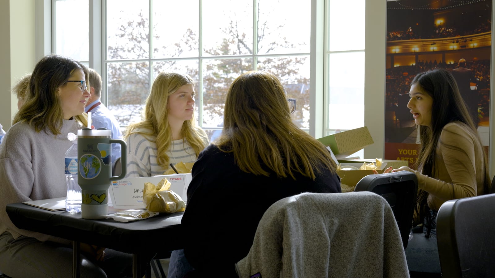 A small group of attendees in discussion at a table during the summit.
